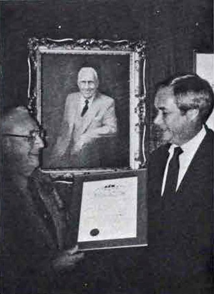Delta Sigma Pi - Delta Tau Chapter, George J. Eberhart shows Dean Edward L. Goebel his Golden Helmet Award, 1983