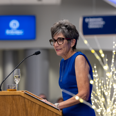 Rita Burns Senseman speaking at a podium giving a toast